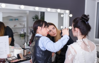 Cosmetology students watching instructor work on model head